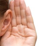 femme qui écoute avec sa main derrière son oreille